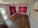Living room with hardwood flooring, windows with curtains, and an entry door at 475 Tennyson St, Denver, CO 80204