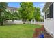 Expansive backyard featuring a well-manicured lawn, an arbor gate, and mature trees providing ample shade at 8721 E 23Rd Ave, Denver, CO 80238