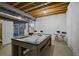 Finished basement with pool table, mini fridge, storage, and a sports area with exposed wooden ceiling at 8721 E 23Rd Ave, Denver, CO 80238