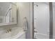 Well-lit bathroom features a shower with glass doors, vanity with sink, and a medicine cabinet at 8721 E 23Rd Ave, Denver, CO 80238