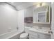 Cozy bathroom featuring white subway tile, a vanity with sink, and a bathtub with shower at 8721 E 23Rd Ave, Denver, CO 80238