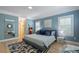Stylish bedroom features hardwood floors, blue accent walls, and two large windows offering natural light at 8721 E 23Rd Ave, Denver, CO 80238