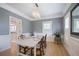 Formal dining room with light-colored wood floors, wainscotting, modern chandelier, and seating for six at 8721 E 23Rd Ave, Denver, CO 80238