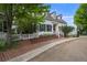 Charming two-story white home featuring black shutters, a brick walkway, and a basketball hoop at 8721 E 23Rd Ave, Denver, CO 80238