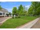 Well-maintained front yard with lush green grass, mature trees, and a charming community gazebo at 8721 E 23Rd Ave, Denver, CO 80238