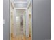 Neutral hallway with hardwood floors leading to a bathroom with glass-door shower at 8721 E 23Rd Ave, Denver, CO 80238