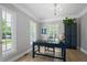Bright home office with hardwood floors, abundant natural light, blue writing desk, and decorative chandelier at 8721 E 23Rd Ave, Denver, CO 80238