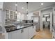 Bright kitchen with stainless steel appliances, center island, wine rack, and white cabinets with black hardware at 8721 E 23Rd Ave, Denver, CO 80238