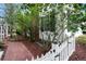 Side yard featuring a brick pathway, white picket fence, and lush greenery for added privacy at 8721 E 23Rd Ave, Denver, CO 80238