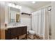 Classic bathroom featuring a wood vanity, updated fixtures, and a shower with a curtain at 11923 E Ford Dr, Aurora, CO 80012