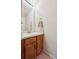 Well-lit half bathroom featuring a vanity with wood cabinets and a decorative mirror at 11923 E Ford Dr, Aurora, CO 80012