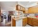 Functional kitchen with wooden cabinets, white appliances, and an open view to the living area at 11923 E Ford Dr, Aurora, CO 80012