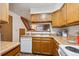 Well-equipped kitchen with wood cabinets and a view of stairs, providing a warm, inviting atmosphere at 11923 E Ford Dr, Aurora, CO 80012