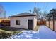 Private backyard features a detached garage, a strip of grass and a wooden fence under a bright, clear sky at 2122 S Ogden St, Denver, CO 80210