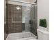 Bathroom showcasing a modern glass-enclosed shower with brown tiling, paired with a toilet and decorative greenery at 2122 S Ogden St, Denver, CO 80210