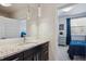 Modern bathroom vanity featuring granite countertop, undermount sink, and a large mirror, with a peek into a blue bedroom at 2122 S Ogden St, Denver, CO 80210