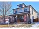 Inviting two-story home with stylish brick accents, a red front door, and a cozy front porch at 2122 S Ogden St, Denver, CO 80210