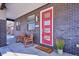 Welcoming front porch featuring rocking chairs, sleek brickwork, and a vibrant red door at 2122 S Ogden St, Denver, CO 80210