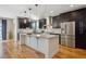 Modern kitchen with stainless steel appliances, a granite island, and dark wood cabinets at 2122 S Ogden St, Denver, CO 80210