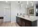 Main bathroom with a double sink vanity, granite counters, and a glass enclosed shower in the background at 2122 S Ogden St, Denver, CO 80210