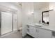 Bright bathroom with white cabinets, stone counter, and shower with glass door enclosure at 1927 S Grant St, Denver, CO 80210