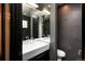 Modern bathroom with dark gray tile walls, double sink vanity, large mirror, and sleek fixtures at 1927 S Grant St, Denver, CO 80210