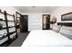Modern bedroom with white linens, unique shelving, dark trim, white walls, and a door to the bathroom at 1927 S Grant St, Denver, CO 80210