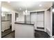 Luxury walk-in closet with custom shelving, mirrored door, black countertop island, chandelier, and carpeted floor at 1927 S Grant St, Denver, CO 80210