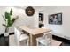 Bright dining area featuring a modern light fixture, white chairs, and unique wall art at 1927 S Grant St, Denver, CO 80210
