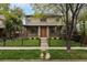 Charming two-story home with stone accents, manicured lawn, and decorative black metal fence at 1927 S Grant St, Denver, CO 80210