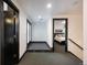 Hallway with dark doors and trim leading to bedroom and bathroom with tile and carpet flooring at 1927 S Grant St, Denver, CO 80210