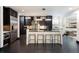 Modern kitchen with dark cabinetry, stainless steel appliances, and a glass-top island with bar stools at 1927 S Grant St, Denver, CO 80210