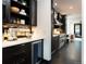 Well-lit kitchen area featuring dark cabinets, stainless steel appliances, and a view into the living room at 1927 S Grant St, Denver, CO 80210