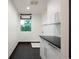 Clean laundry room with white cabinets, black countertops, and a window for natural light at 1927 S Grant St, Denver, CO 80210
