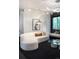 Cozy living room with a curved white sofa, modern lighting, and a glass coffee table at 1927 S Grant St, Denver, CO 80210