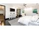 Bright main bedroom featuring a ceiling fan, TV, with a comfortable chaise lounge and modern decor at 1927 S Grant St, Denver, CO 80210