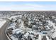 Winter aerial view of a residential neighborhood with snow-covered houses and streets at 12061 Ivy Way, Brighton, CO 80602