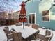 Backyard area with patio seating, featuring an umbrella and a sliding glass door leading into the house at 12061 Ivy Way, Brighton, CO 80602
