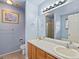 Bright bathroom with double sink vanity, tiled floor, and a framed art print at 12061 Ivy Way, Brighton, CO 80602