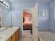 Bathroom showcasing a double sink vanity, soaking tub, and an open doorway to the Primary suite at 12061 Ivy Way, Brighton, CO 80602