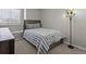 Cozy bedroom featuring a twin bed with soft gray bedding and a colorful floor lamp at 12061 Ivy Way, Brighton, CO 80602
