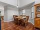 Dining area featuring hardwood floors, a classic wooden table with chairs, and ample natural light at 12061 Ivy Way, Brighton, CO 80602