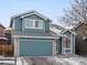 Charming two-story home showcases blue siding, a garage, and manicured landscaping at 12061 Ivy Way, Brighton, CO 80602