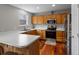 Bright kitchen featuring wood cabinets, stainless steel appliances, and a large countertop at 12061 Ivy Way, Brighton, CO 80602