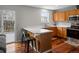 Kitchen featuring an eating bar, wood cabinets, stainless steel appliances, and hardwood floors at 12061 Ivy Way, Brighton, CO 80602