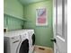 Cozy laundry room featuring side-by-side washer and dryer, built in shelving, and a bright window at 12061 Ivy Way, Brighton, CO 80602
