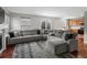 Spacious living room featuring a large gray sectional, hardwood floors, and natural light at 12061 Ivy Way, Brighton, CO 80602
