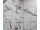 Modern shower with elegant marble-like tiling and updated fixtures for a spa-like experience at 12061 Ivy Way, Brighton, CO 80602