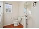 Classic bathroom with a pedestal sink, toilet, and a window for natural light at 21642 E 55Th Ave, Denver, CO 80249