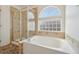 Bathroom featuring a soaking tub and a glass-enclosed shower at 21642 E 55Th Ave, Denver, CO 80249